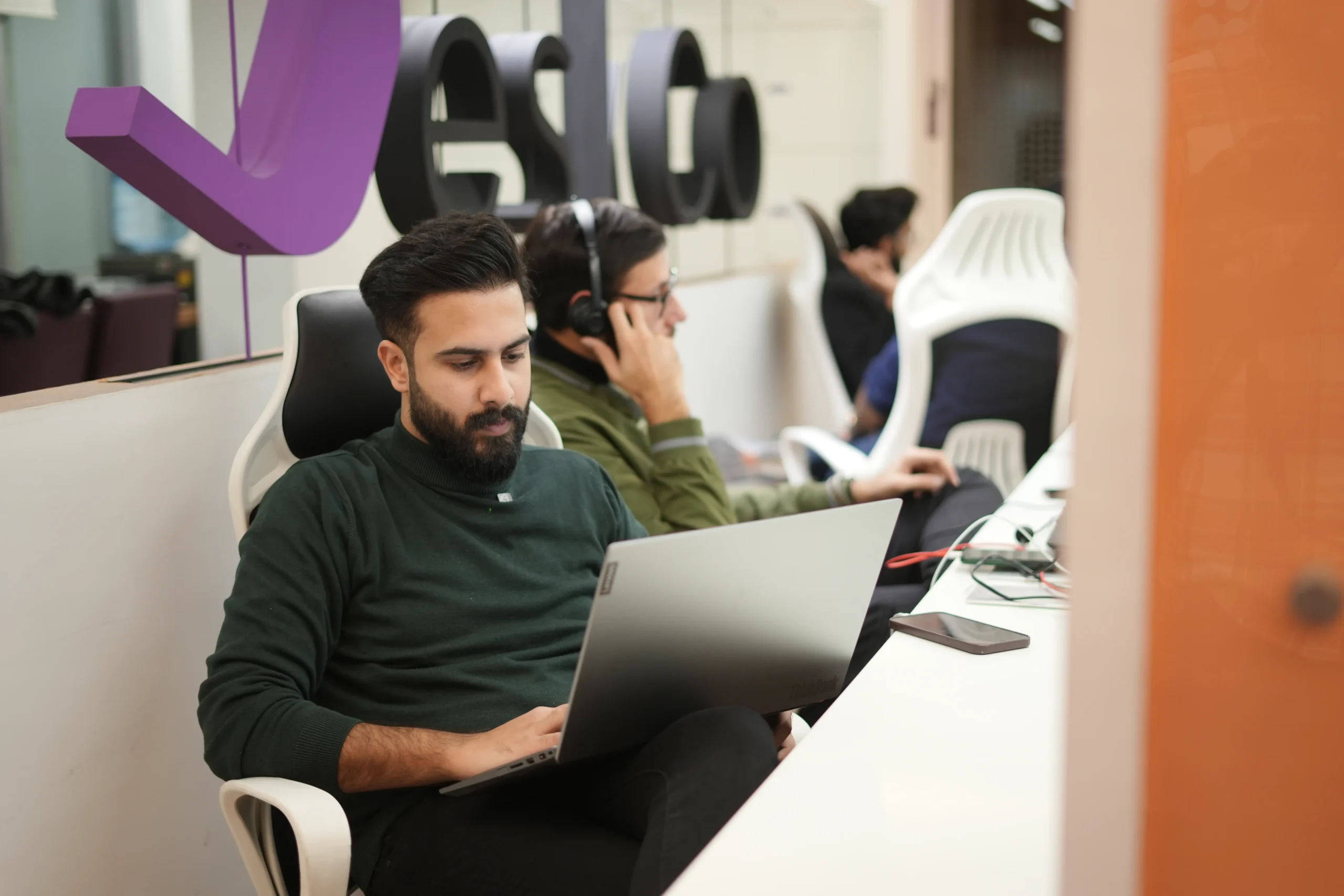 Two associates working at desks in open office, illustrating local hiring costs