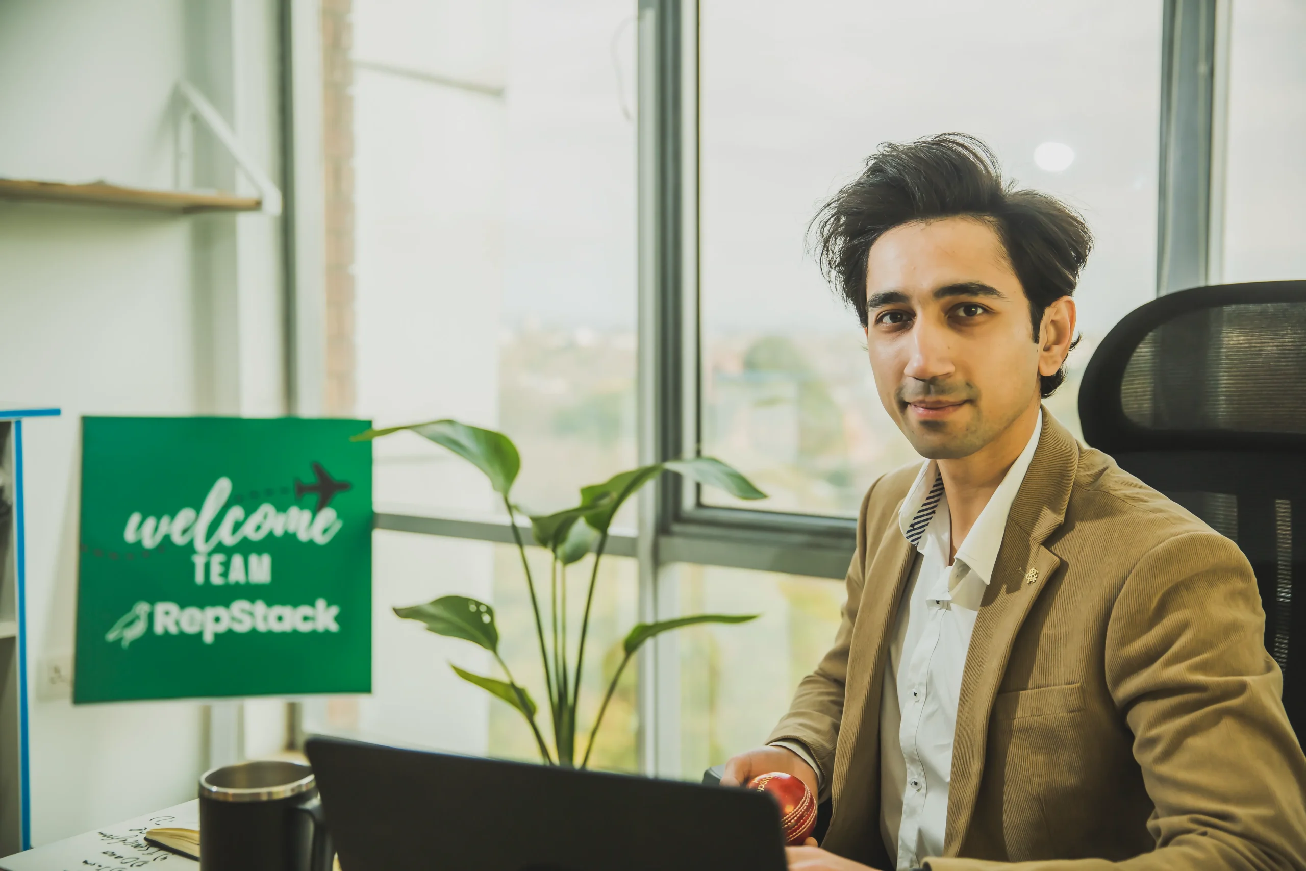RepStack associate at desk with "Welcome Team" sign in background.
