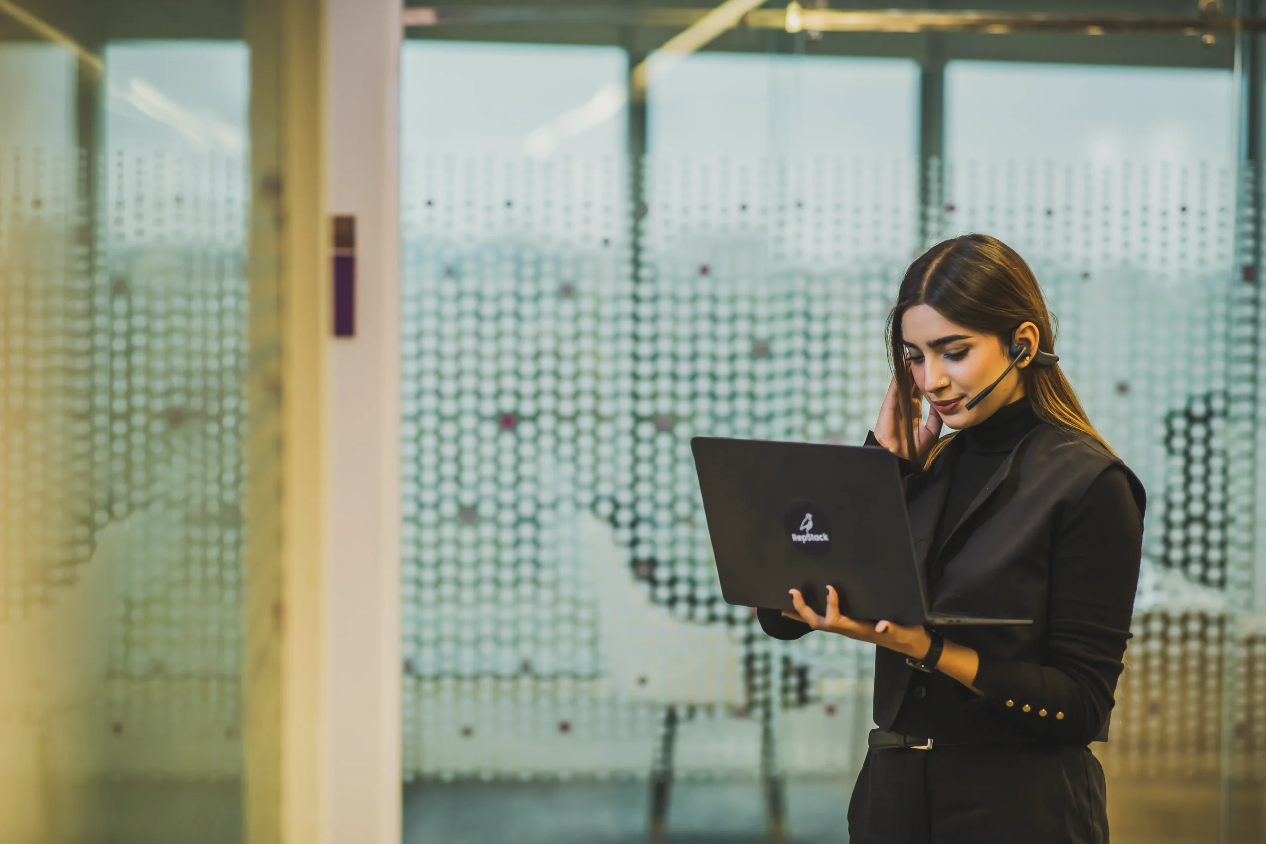 Associate reviewing branded laptop while standing.